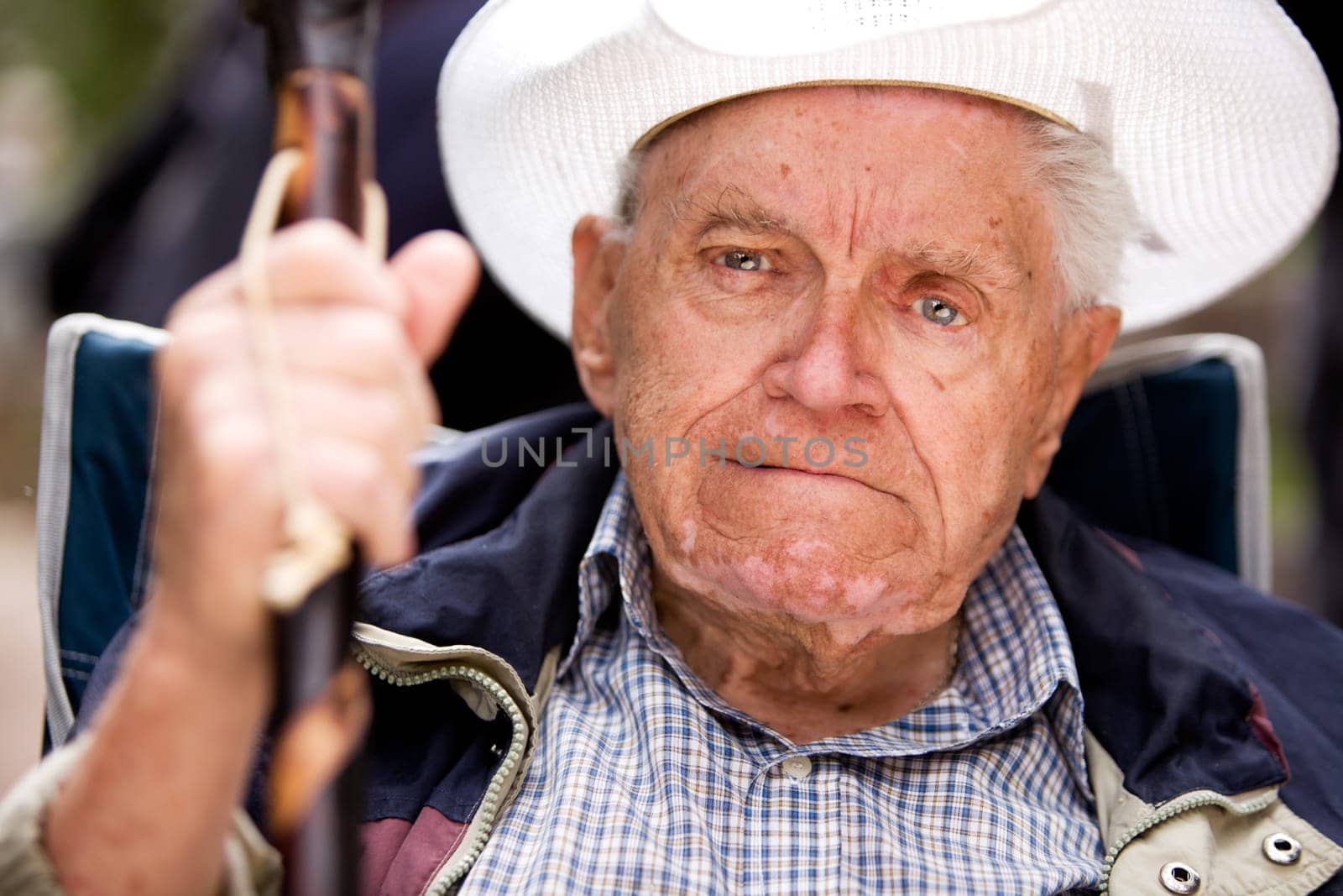 A portrait of a grumpy old man sitting in a chair