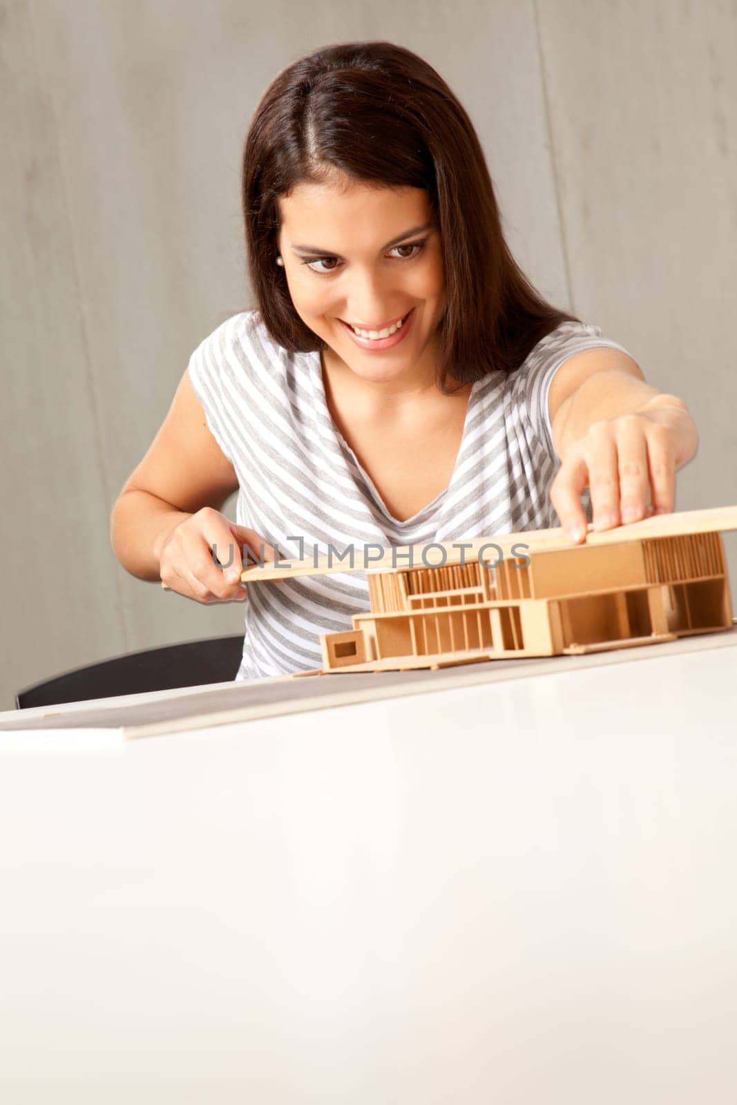 A young architect designing and building a model house