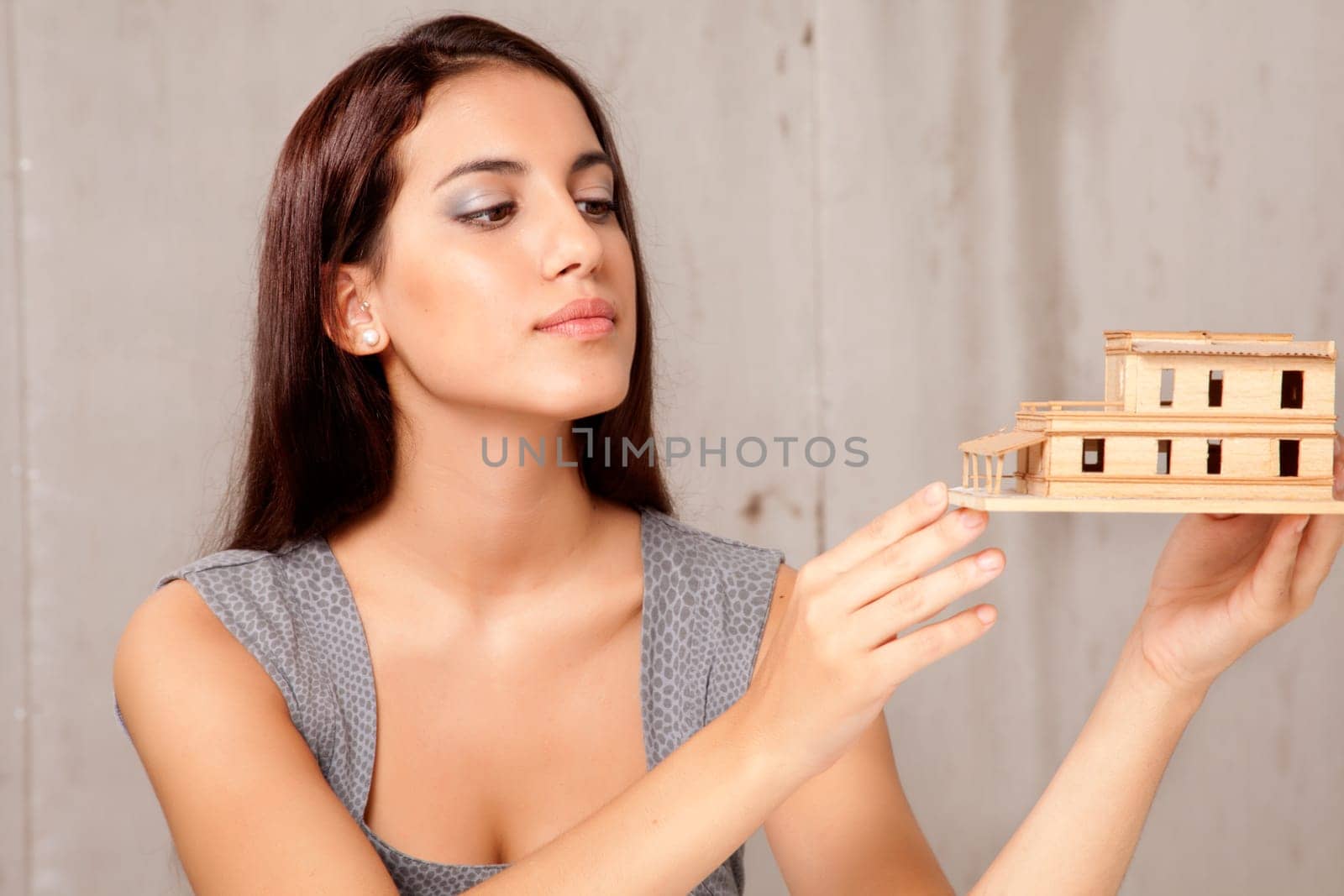 A young female architect or designer looking at a rough house model