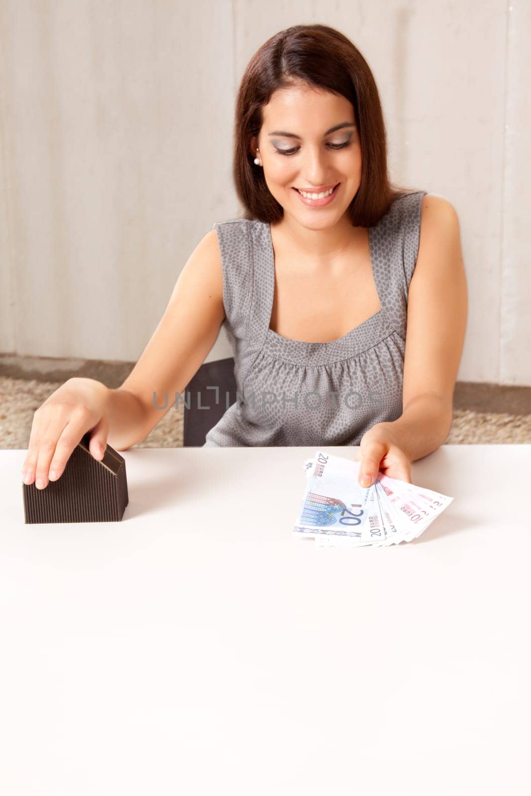 A woman holding out money (euro) in exchange for a house