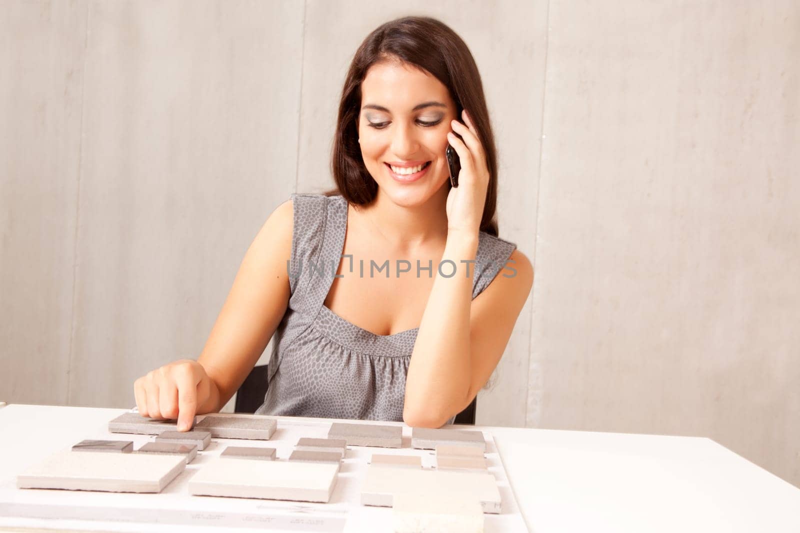 An architect / designer talking on the phone choosing a stone tile
