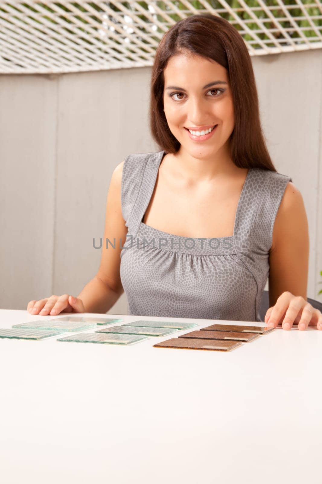 Woman choosing between various glass tile samples, critical focus on tiles