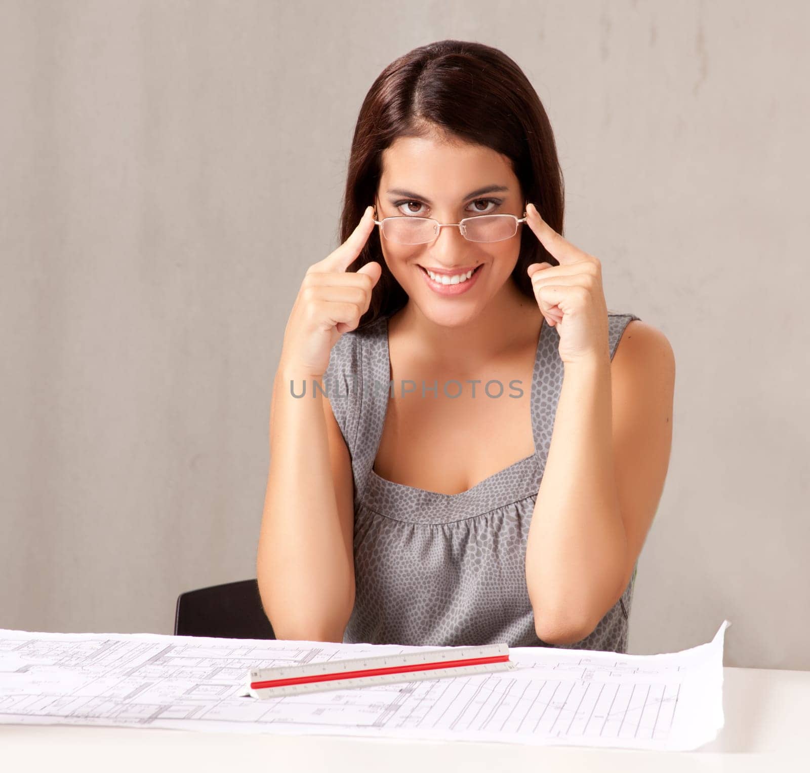 A portrait of a female architect looking at blueprints