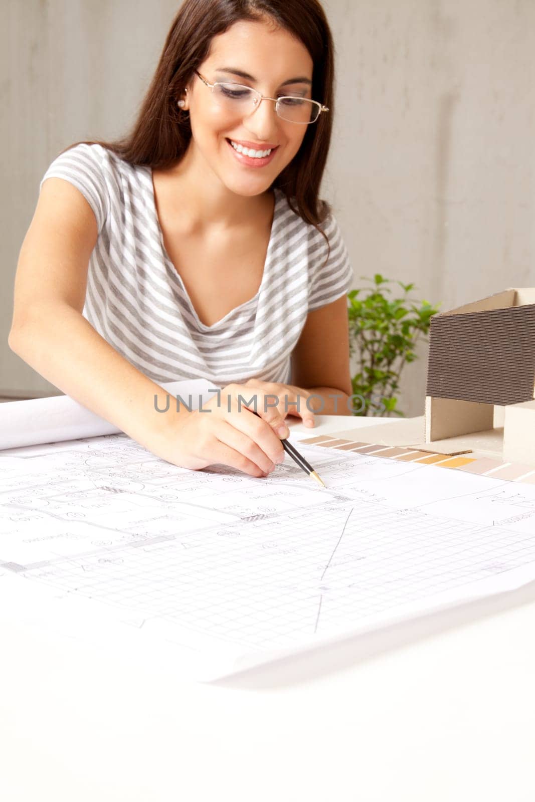A female architect looking blueprints in an office