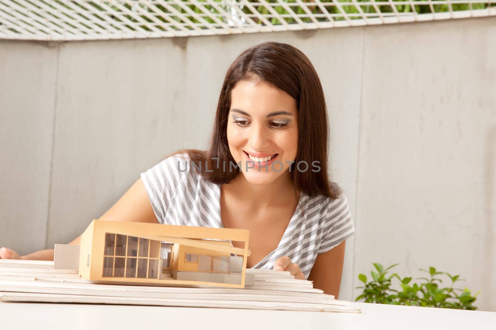 A female architect looking at a model house
