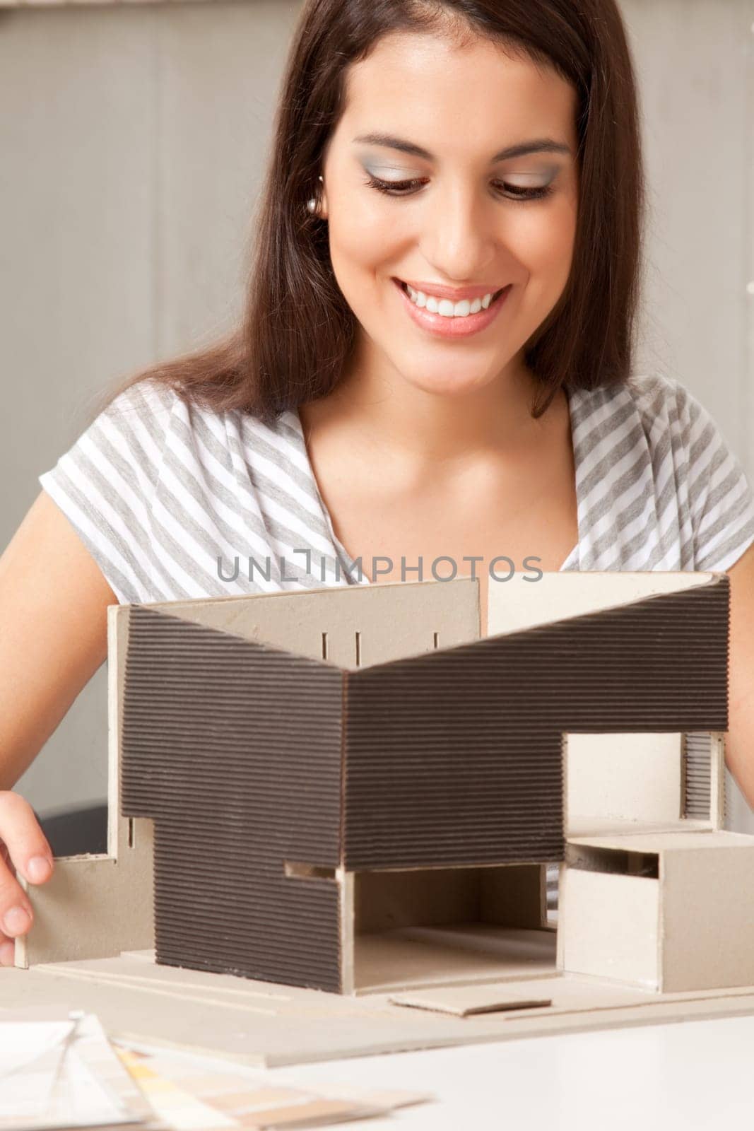 A young design student or architect building a house model