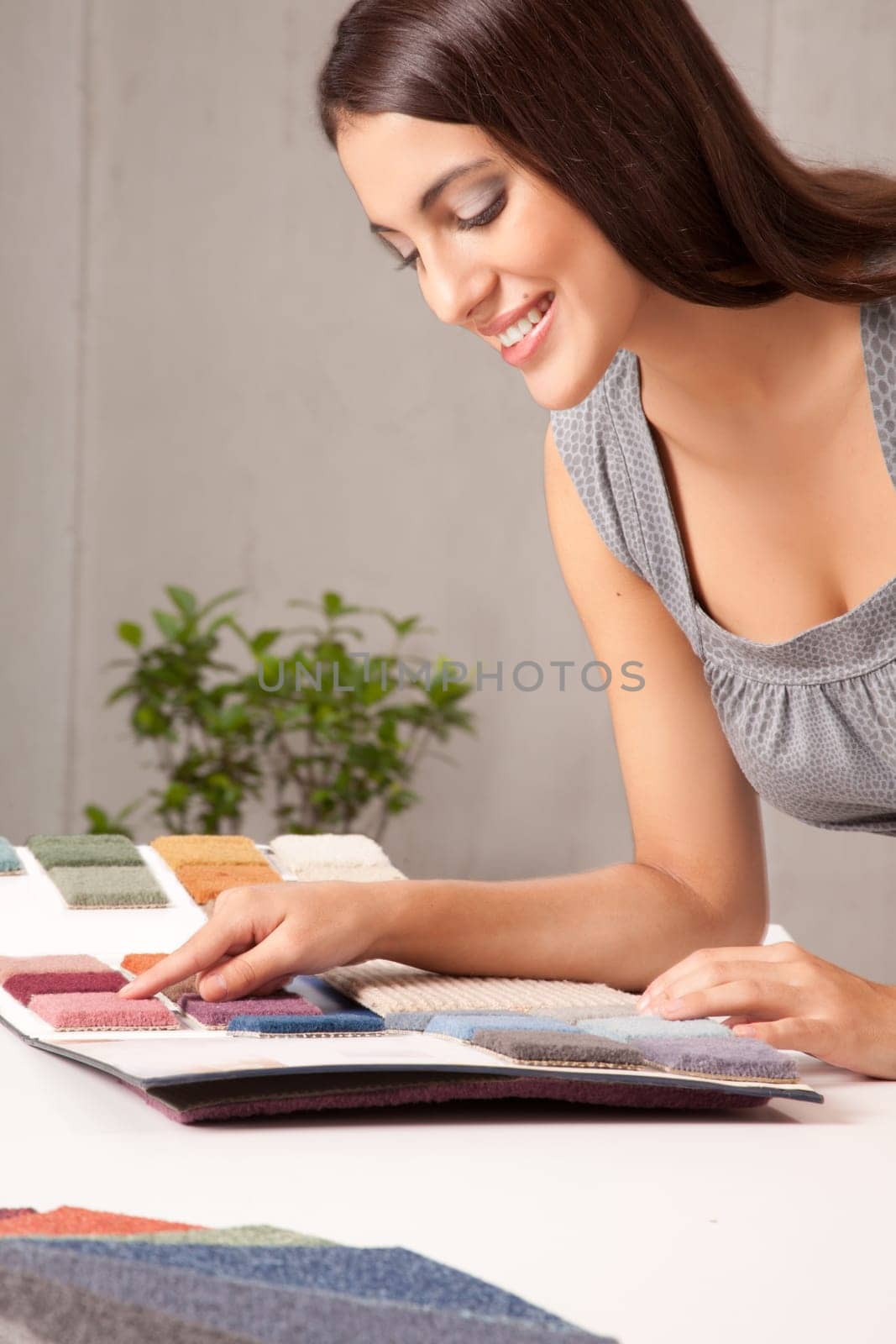 A young female designer choosing a carpet sample from a catalogue