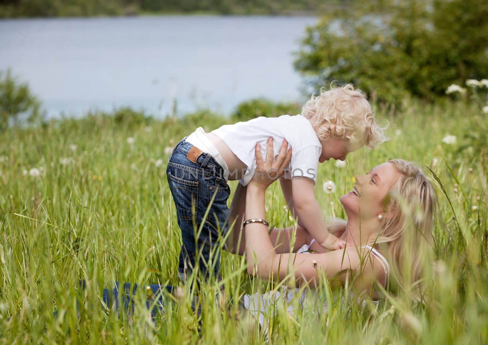 A mother and child together in a meadow playing and having fun