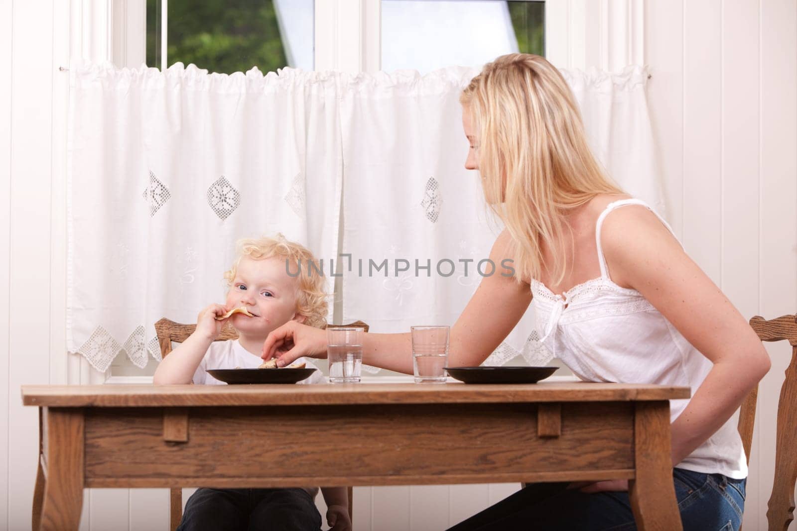 A mother and son eating lunch at a table