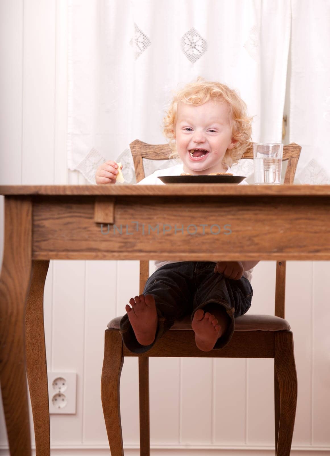 An excited child laughing and looking at the camera with an excited expression