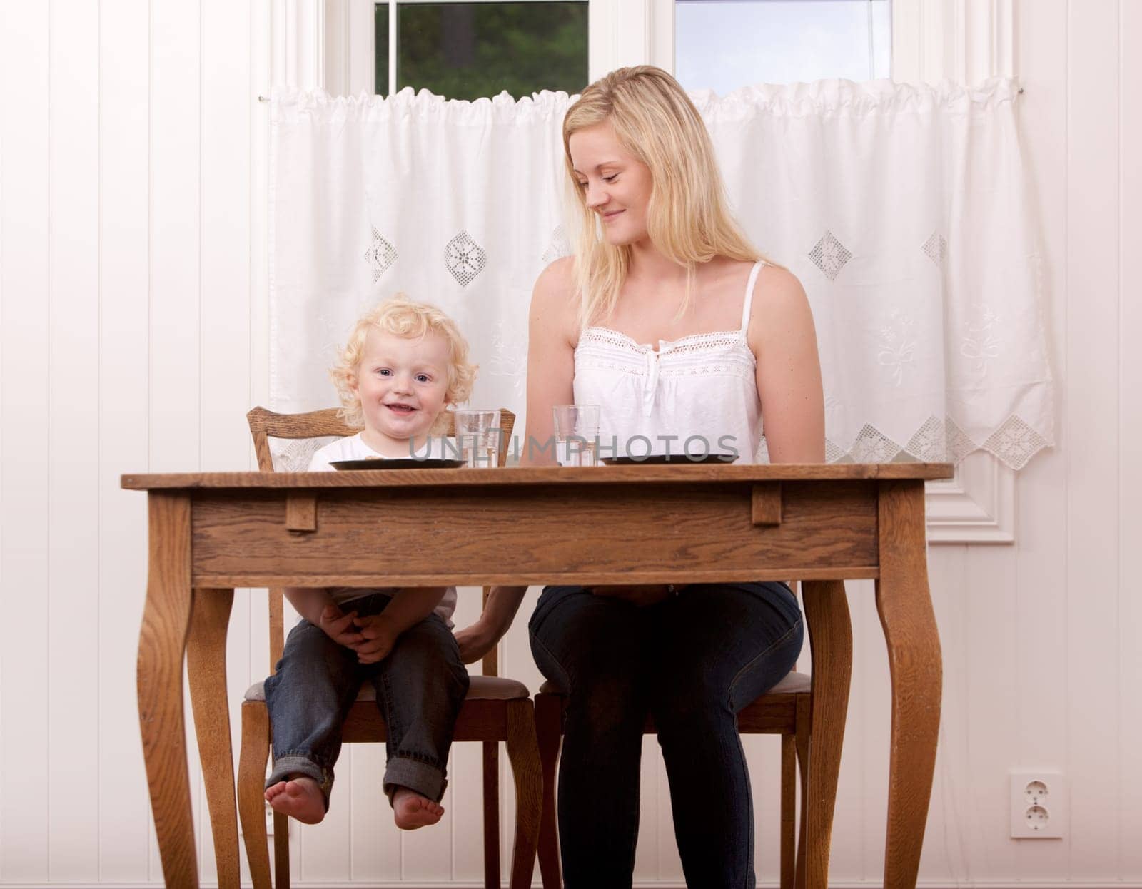 A happy smiling mother and child sitting at a table