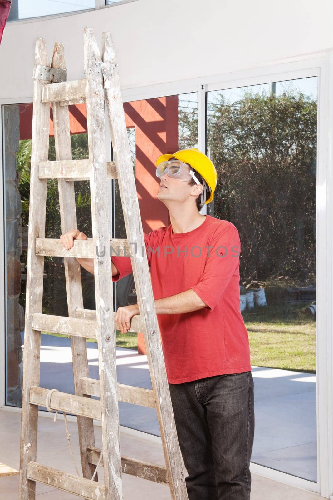 Engineer wearing helmet and eyegear and holding ladder