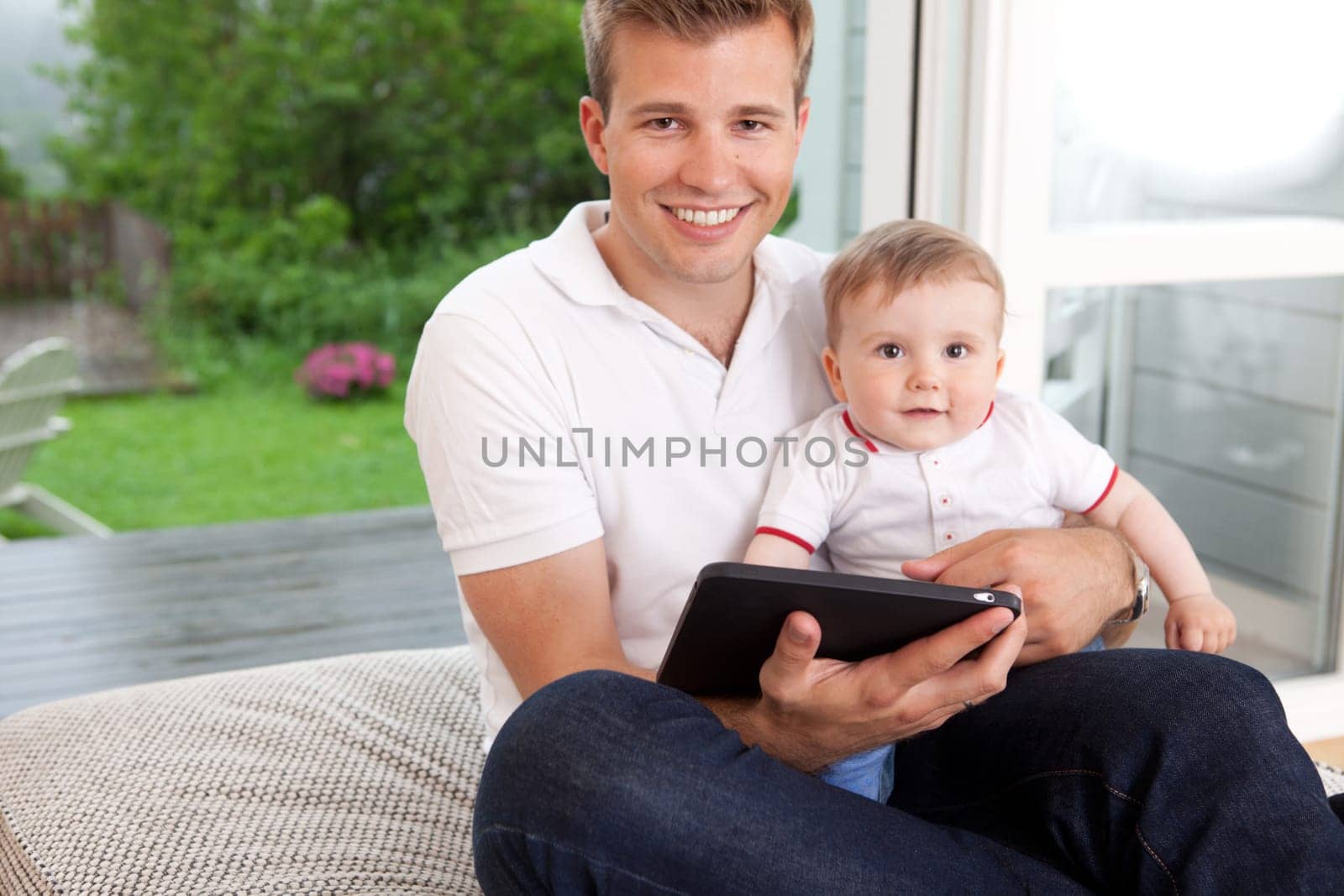 Portrait of a father and son with a digital tablet in a home interior