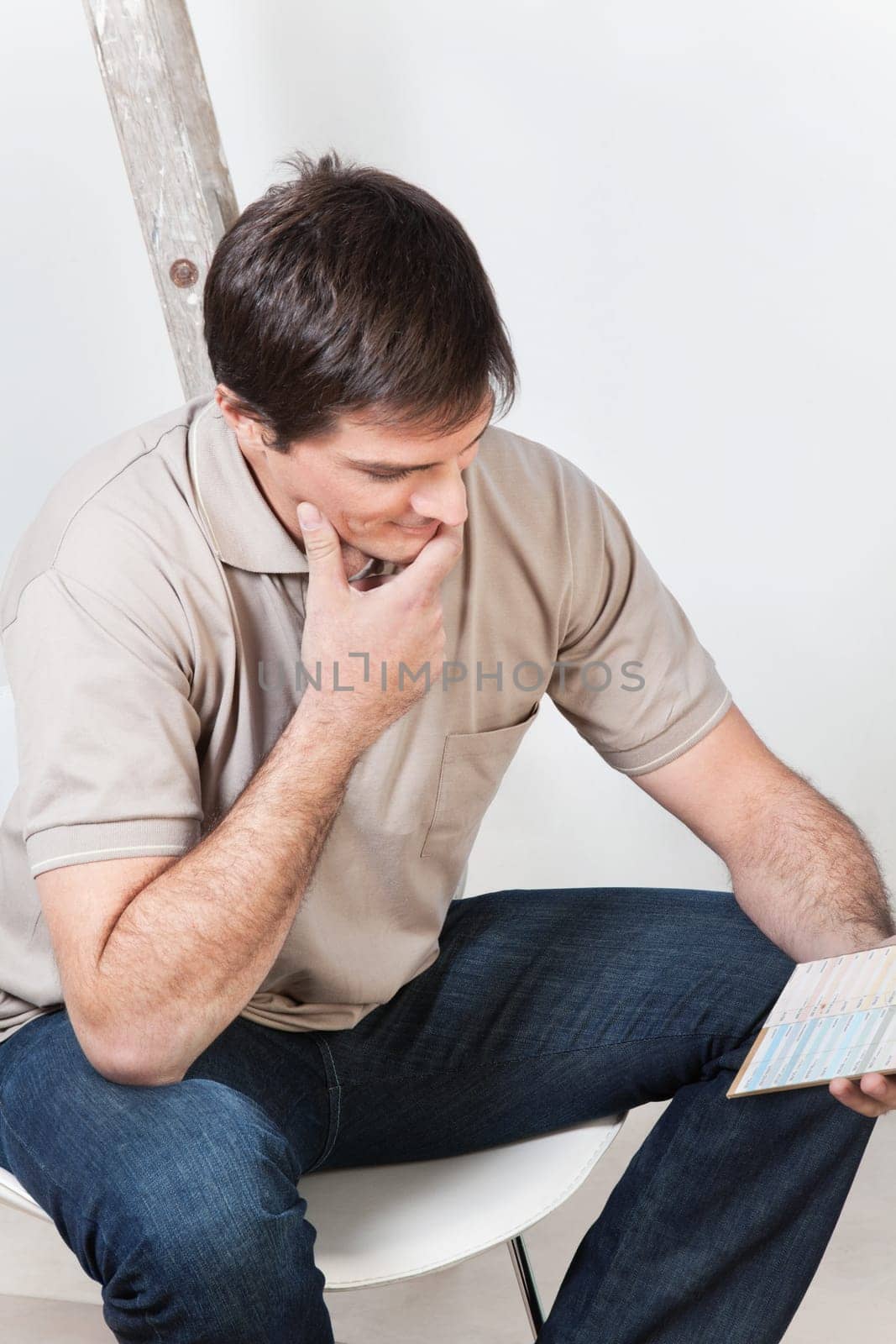 Portrait of young confused man looking at color guide
