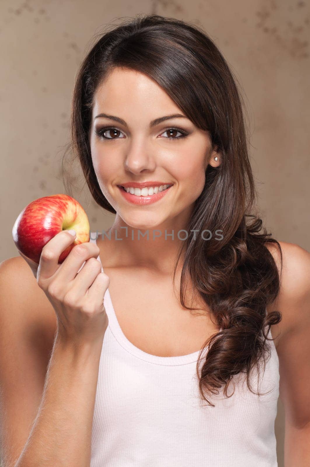 Close-up portrait of young beautiful woman holding an apple