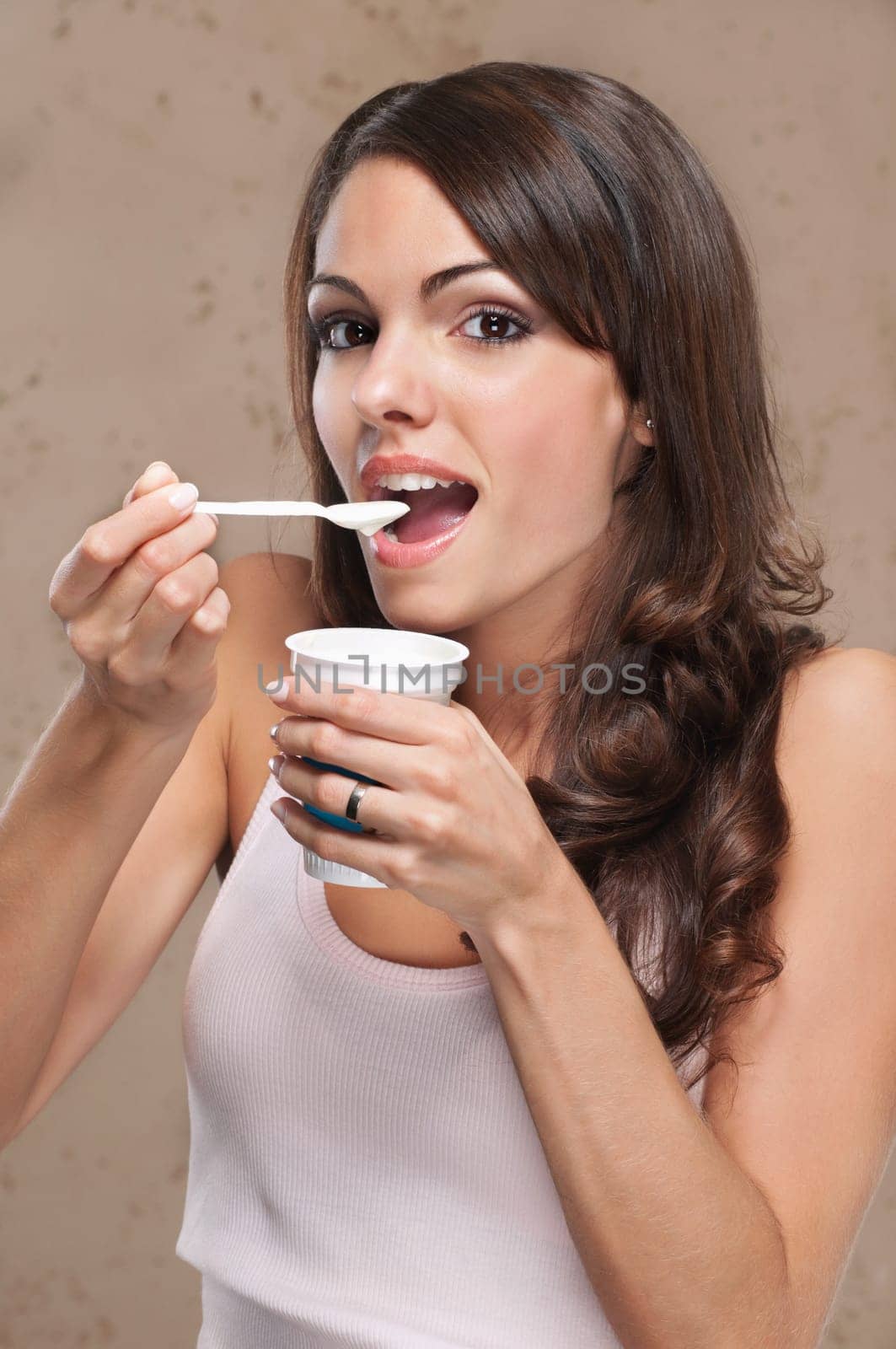 Portrait of young beautiful woman eating yogurt
