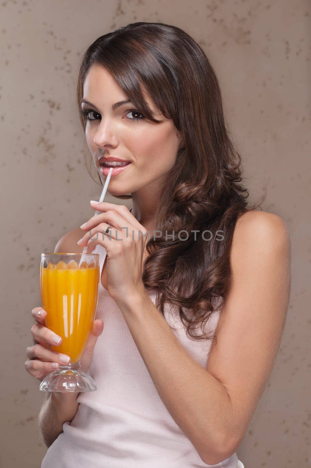 Smiling portrait of an attractive woman drinking orange juice