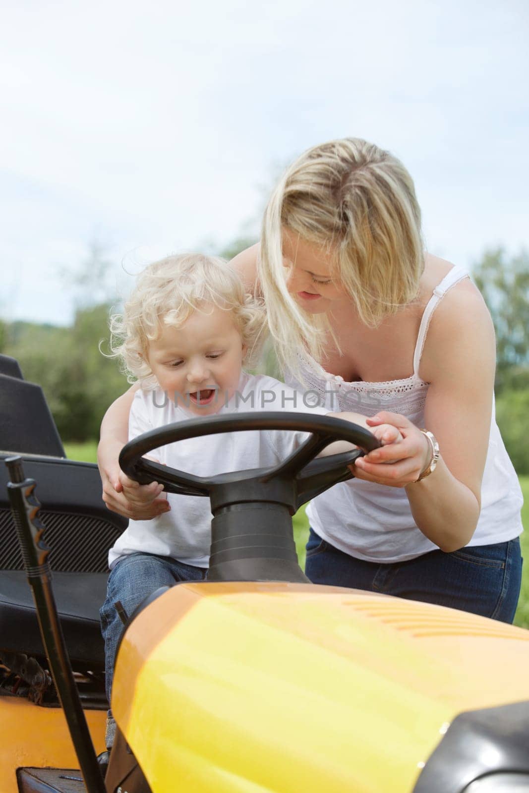 Young female with her son holding steering wheel
