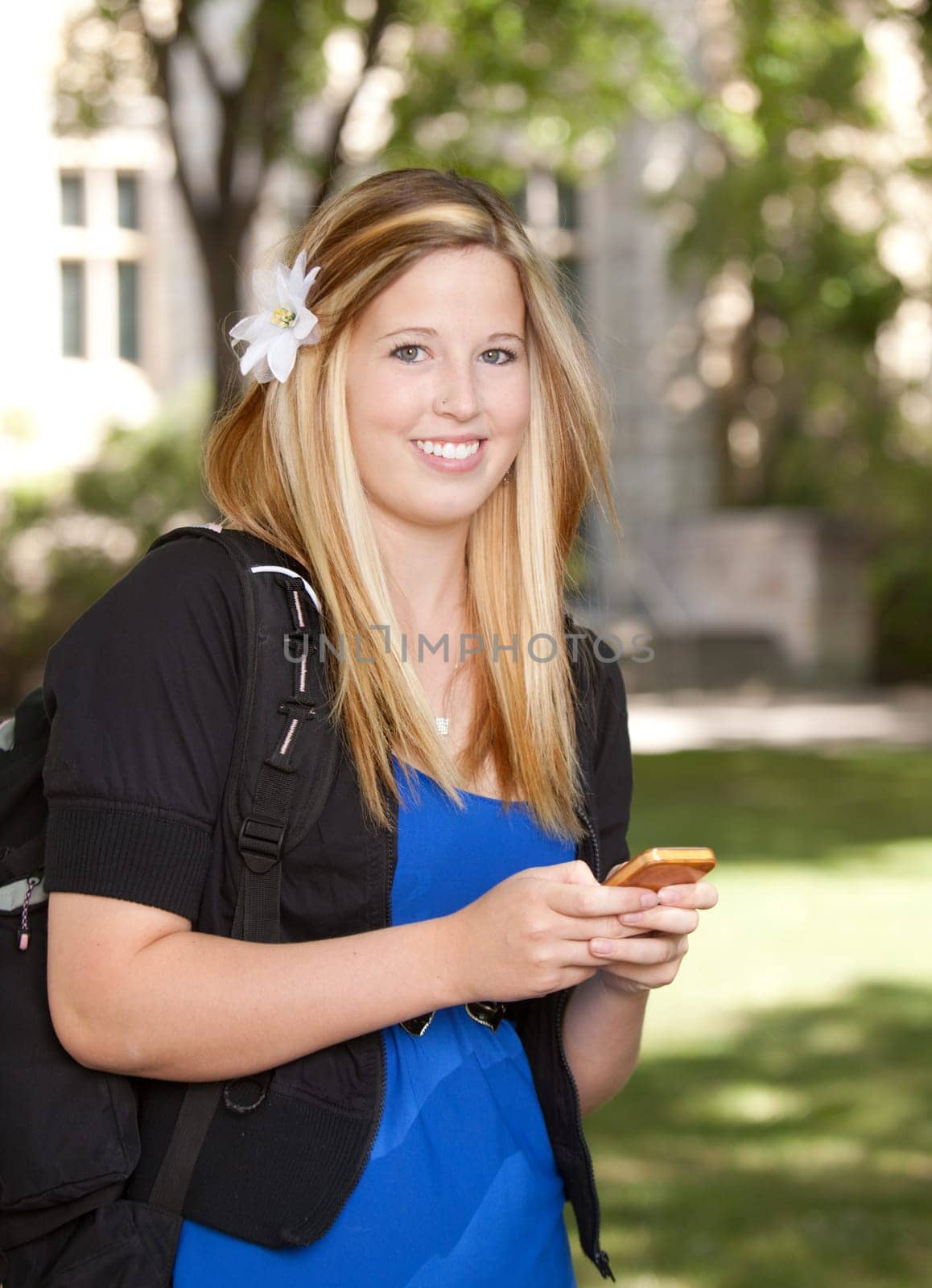 Young pretty college girl texting on phone
