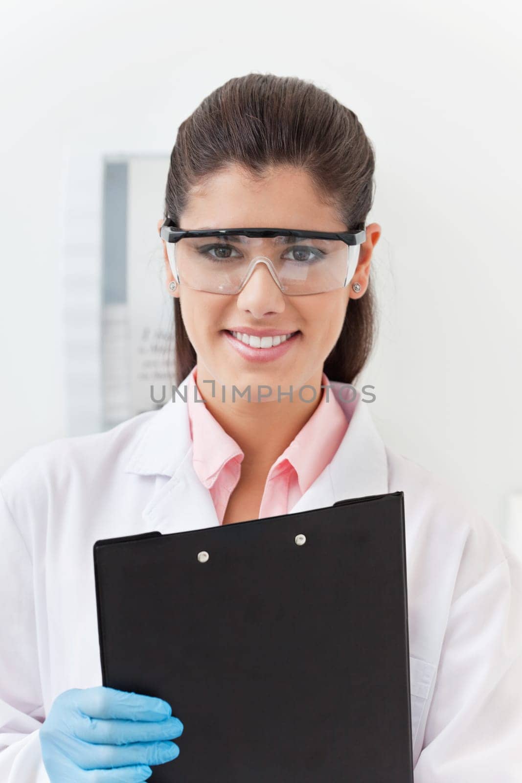 Smiling confident young dentist holding clipboard