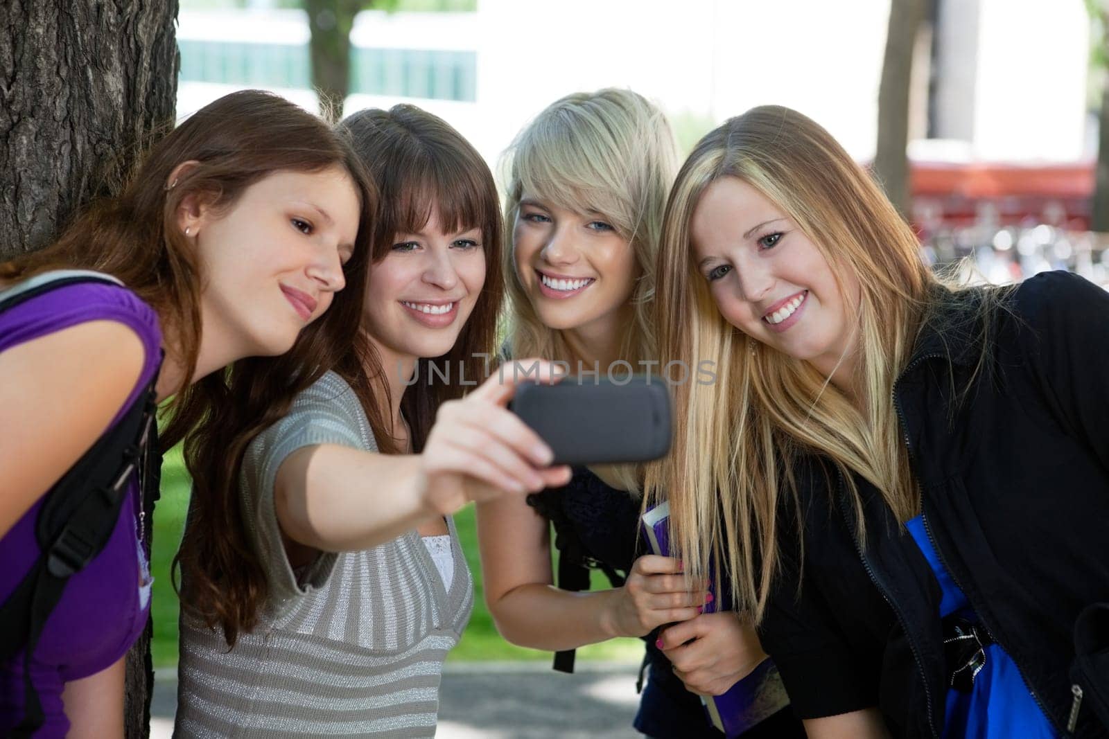 Teenage girl taking a self-portrait of her female friends