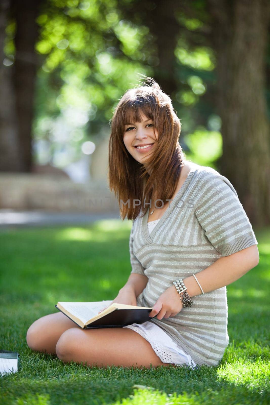 Portrait of college student sitting on campus lawn