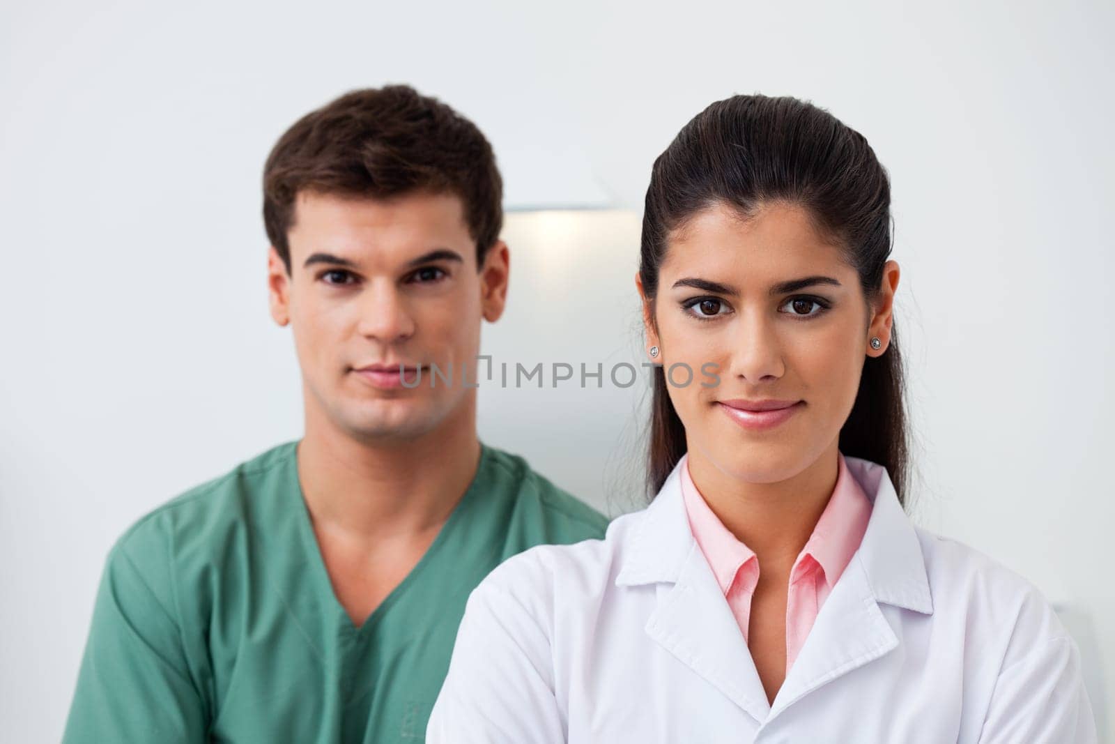 Portrait of female dentist standing with her assistant