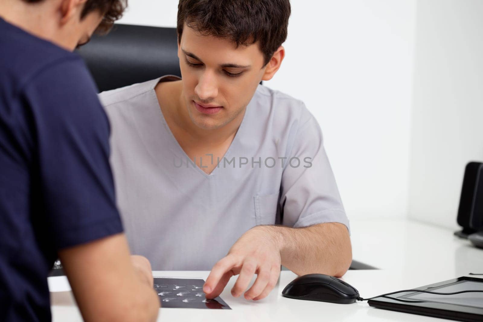 Doctor consulting patient on his report at clinic