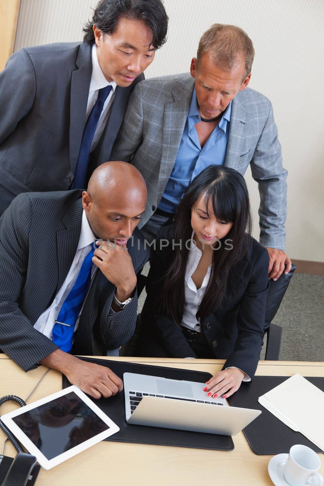 Portrait of serious business team working on laptop together