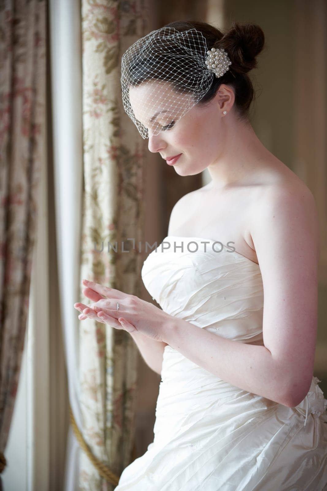 pretty bride in wedding dress looking at her wedding ring