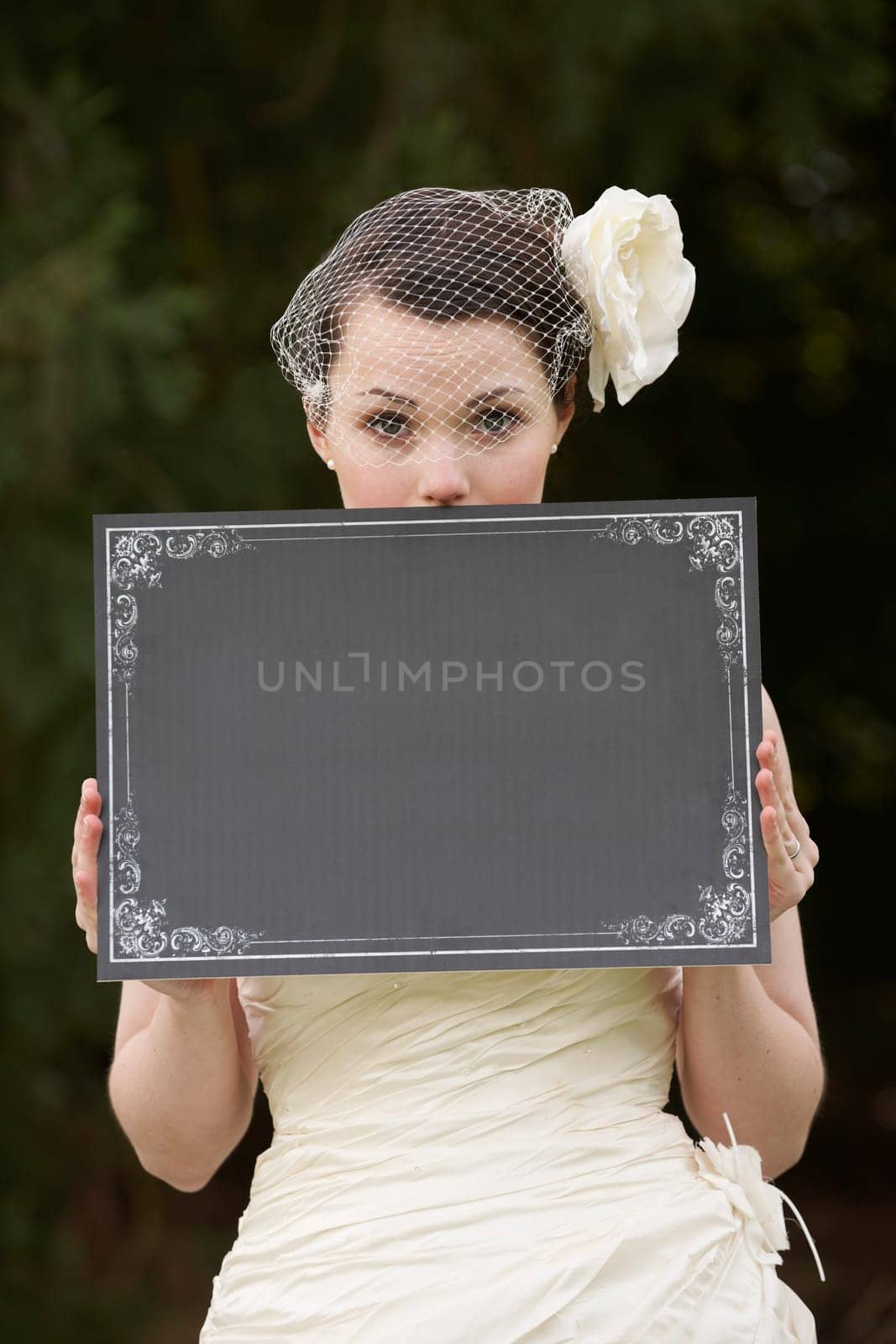 Pretty bride in wedding dress holding a blank board with space for copy