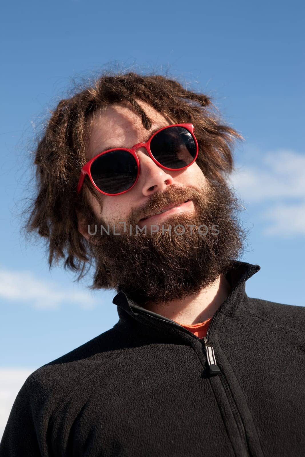 A funny portrait of a male with a full beard and sunglasses
