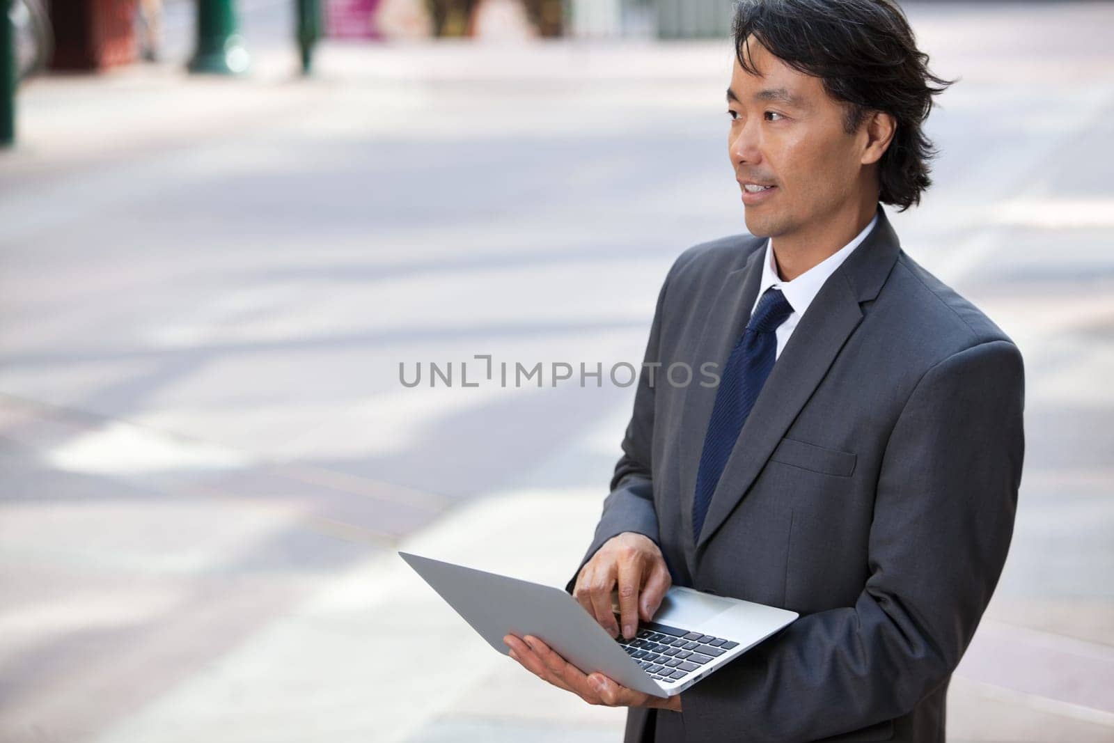 Handsome businessman using laptop outdoors