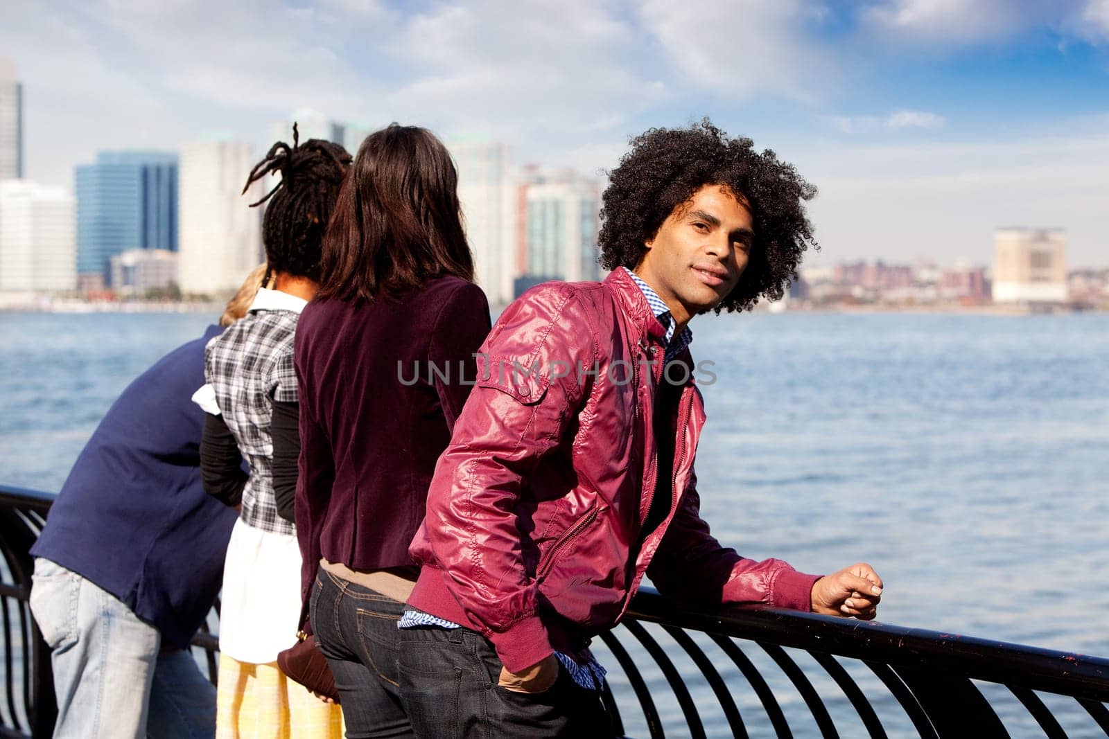 An African American looking at the camera with a group of friends in the background