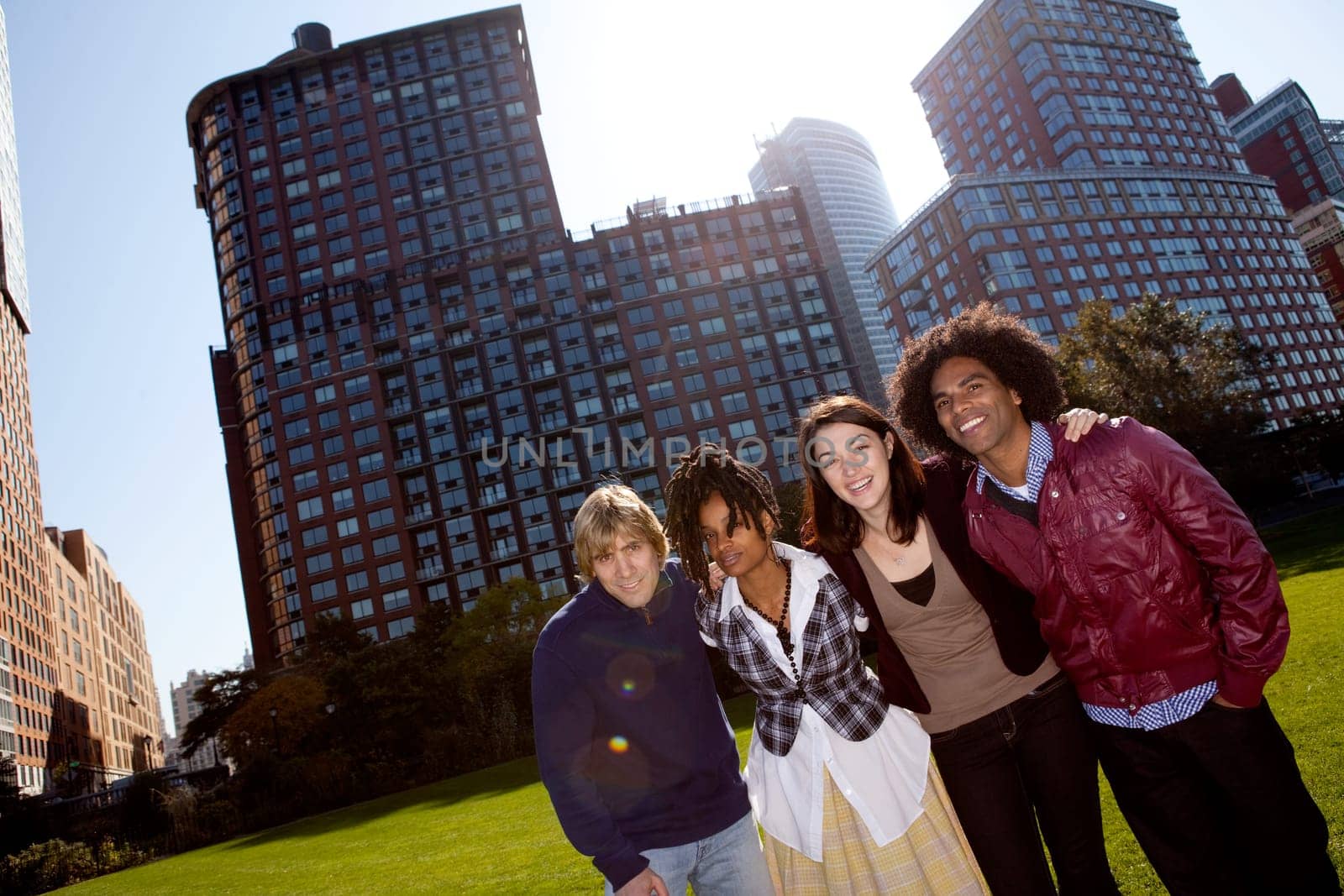 A group of people in front of an apartment building taken into the sun with solar flare