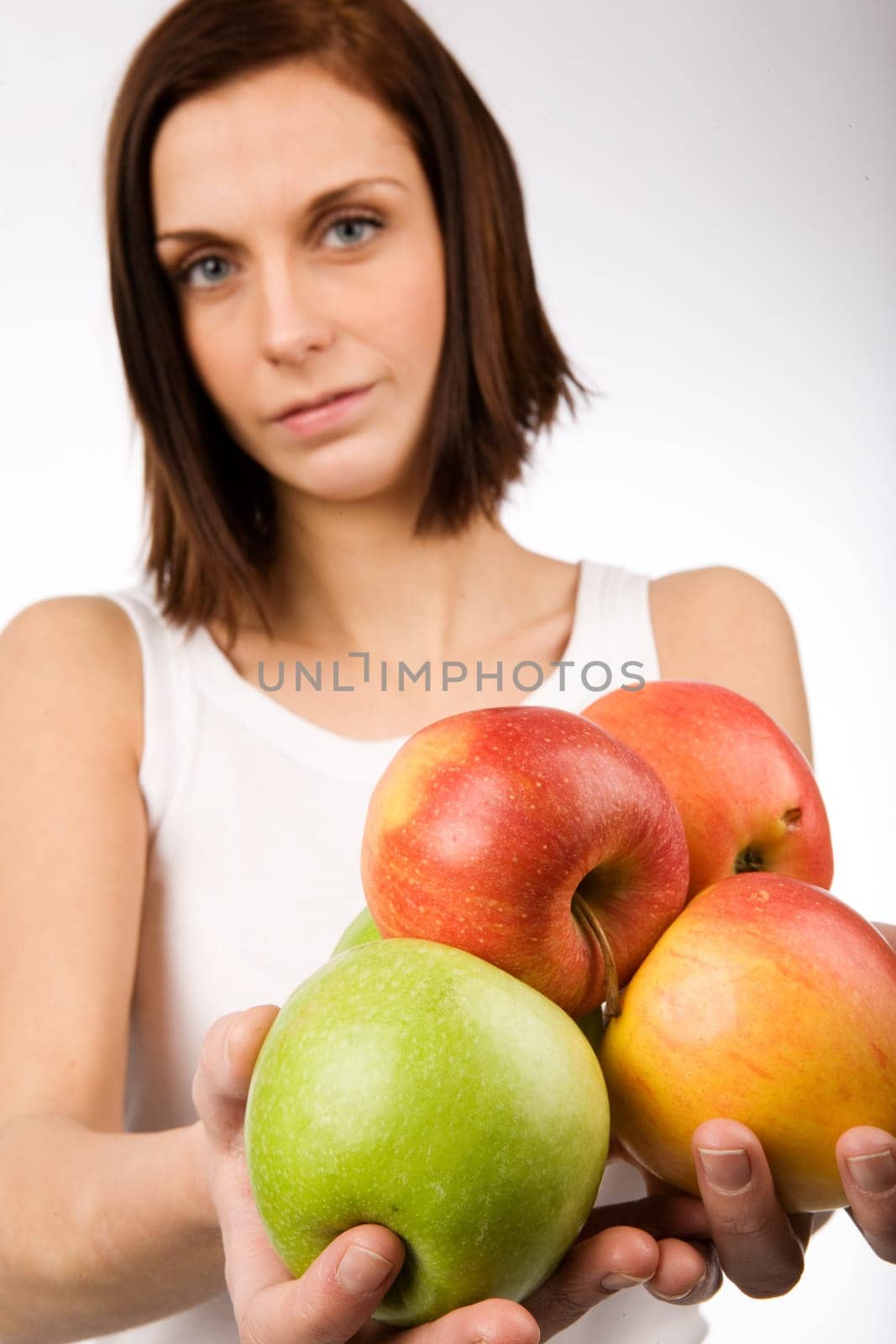A young woman holding a bunch of apples