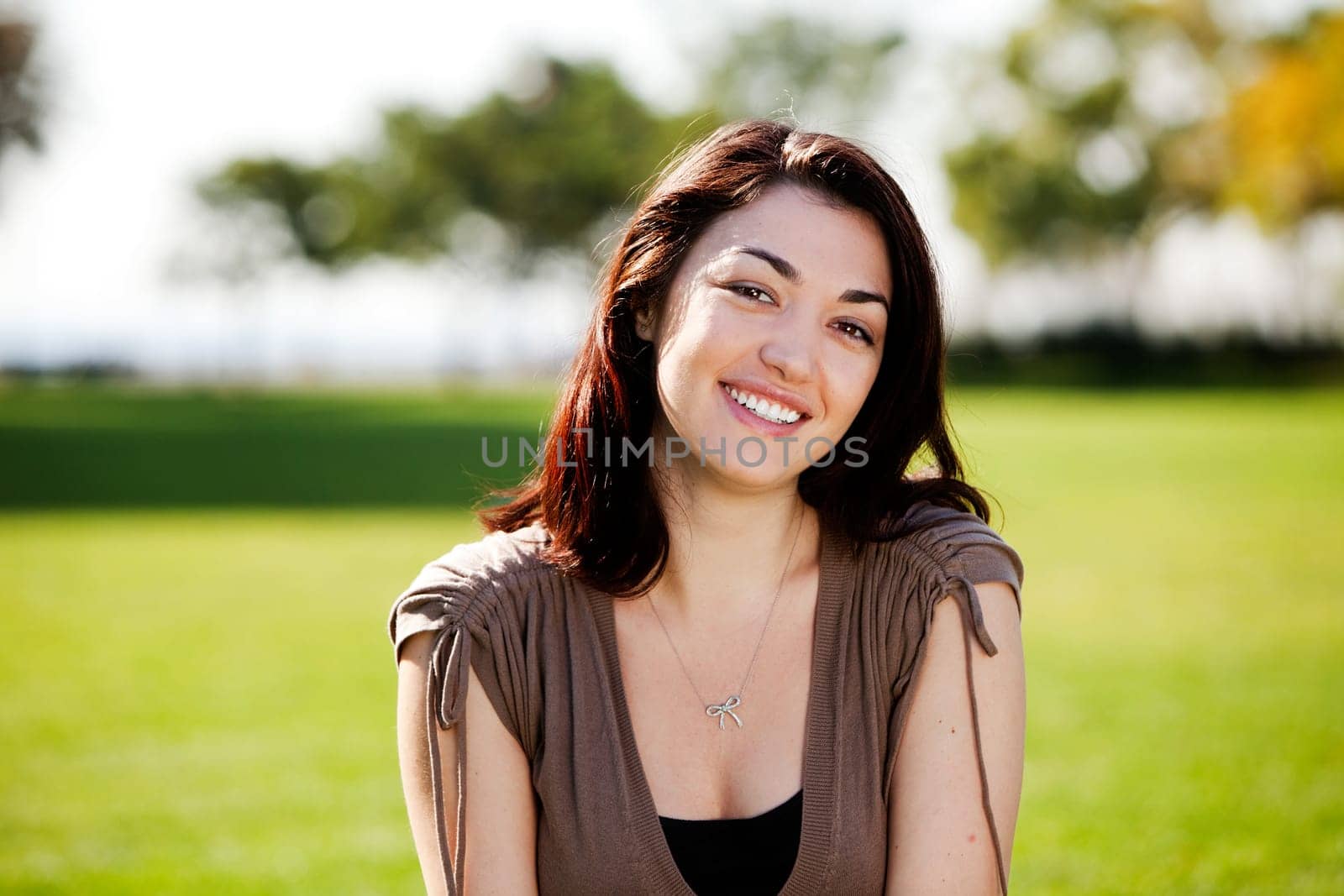 A happy young student outside in a park
