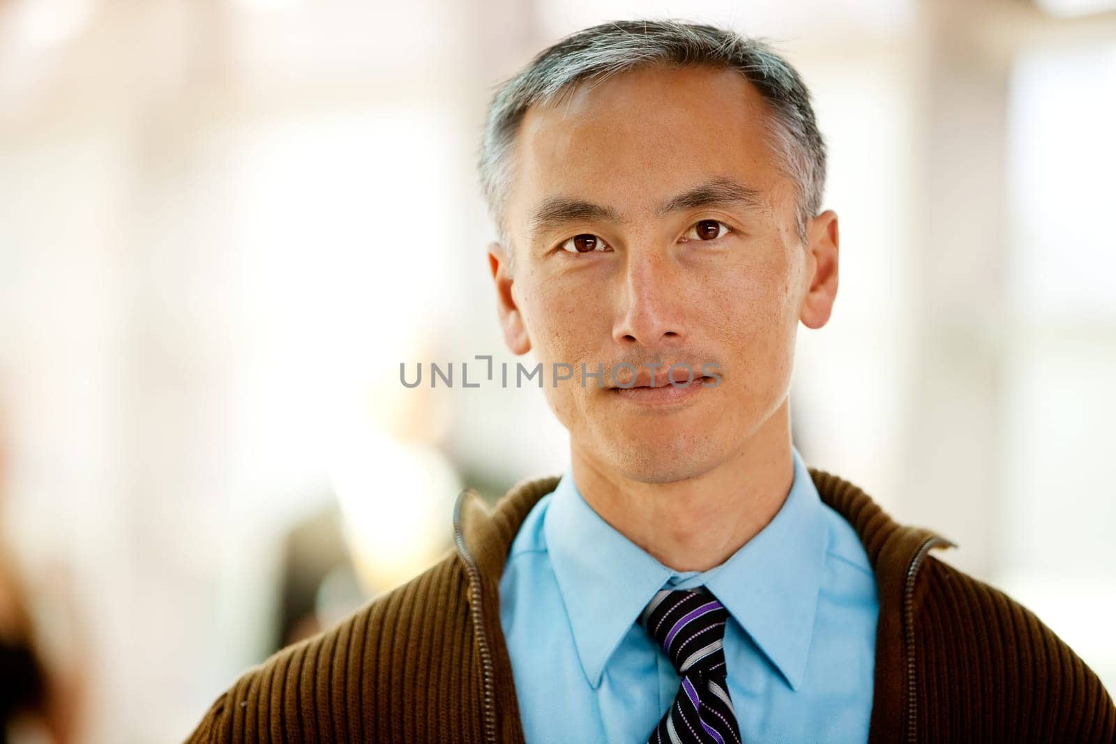 A portrait of a semi casual business man with colleagues in the background