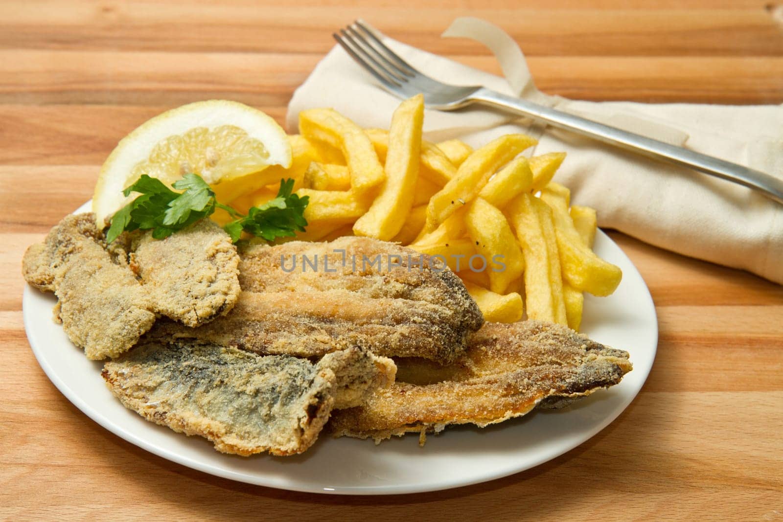 a dish with sardines fried and potate