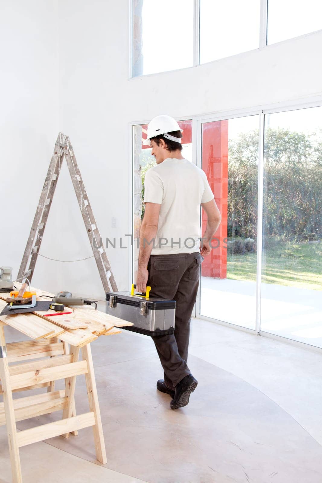 A faceless man with a tool chest, working on home improvements