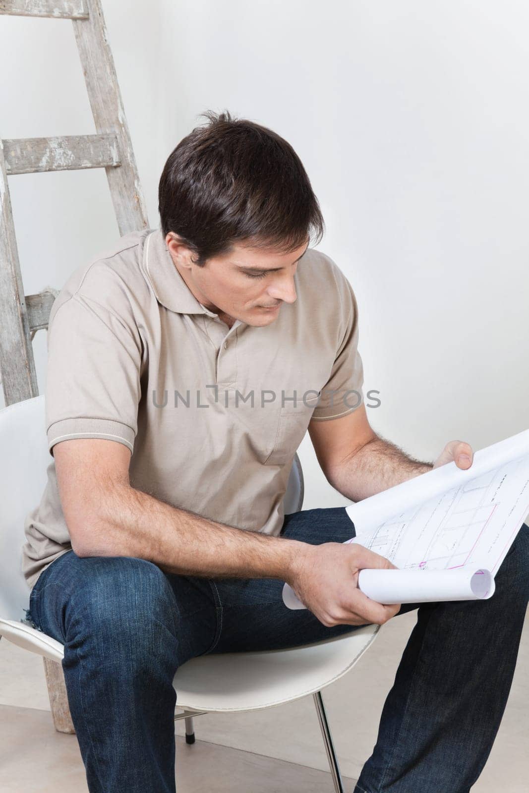 Portrait of young smart man looking at blueprint