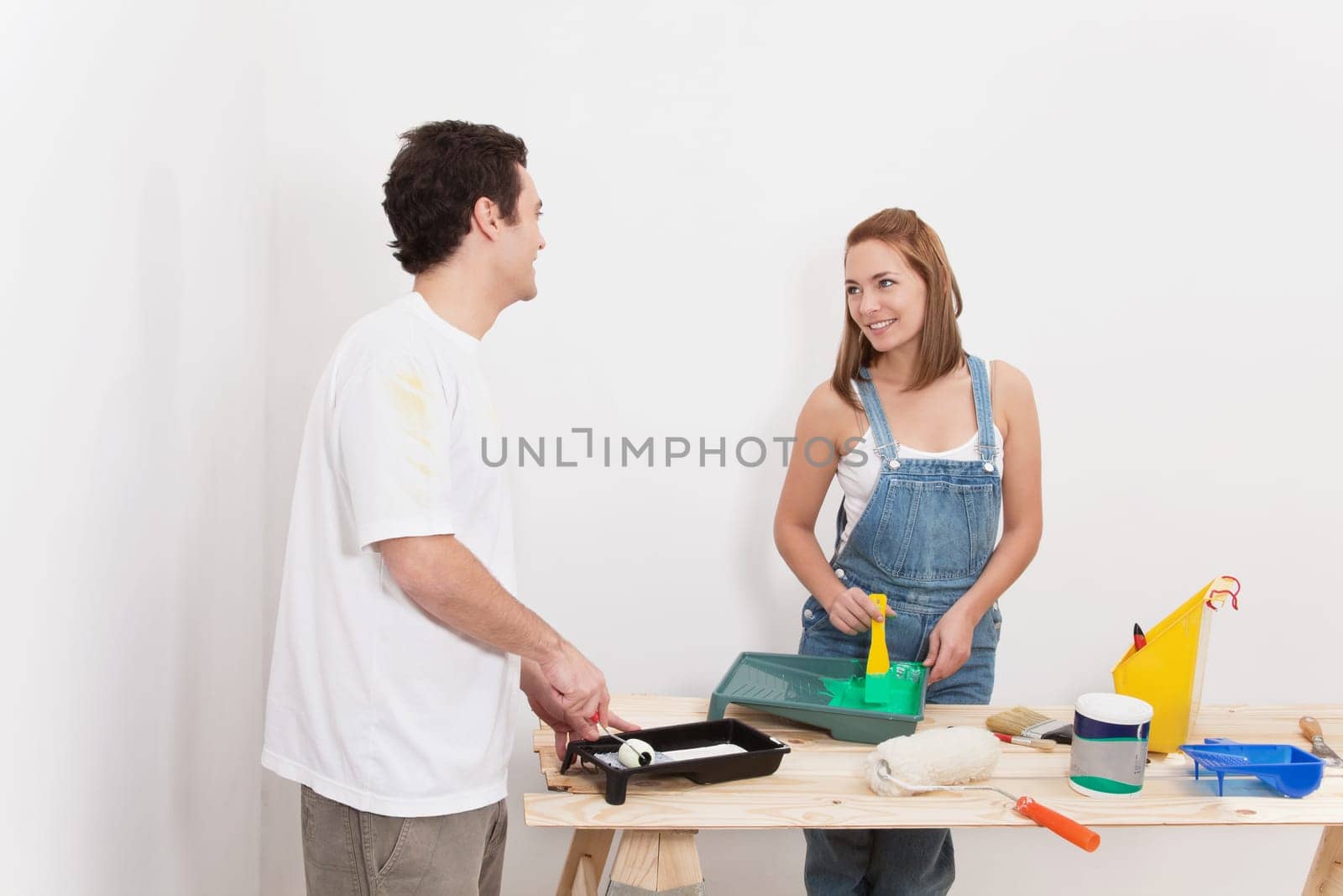Young couple smiling at each other while mixing paint