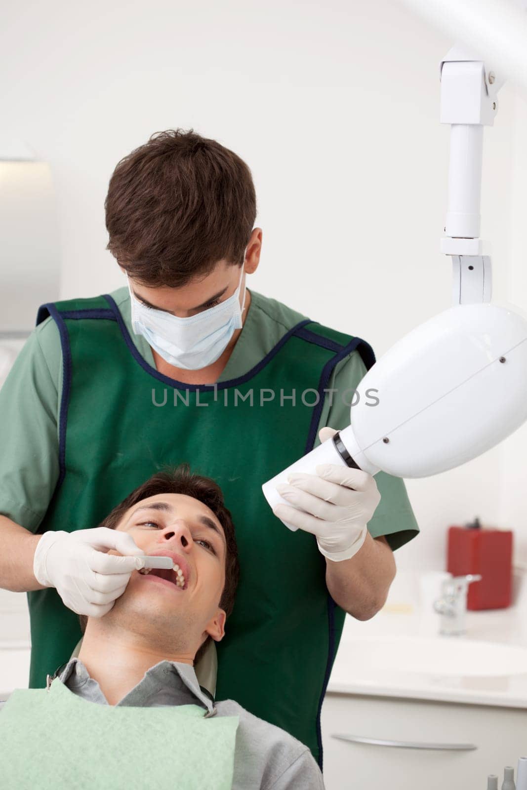 Young male dentist preparing an x-ray on a patient