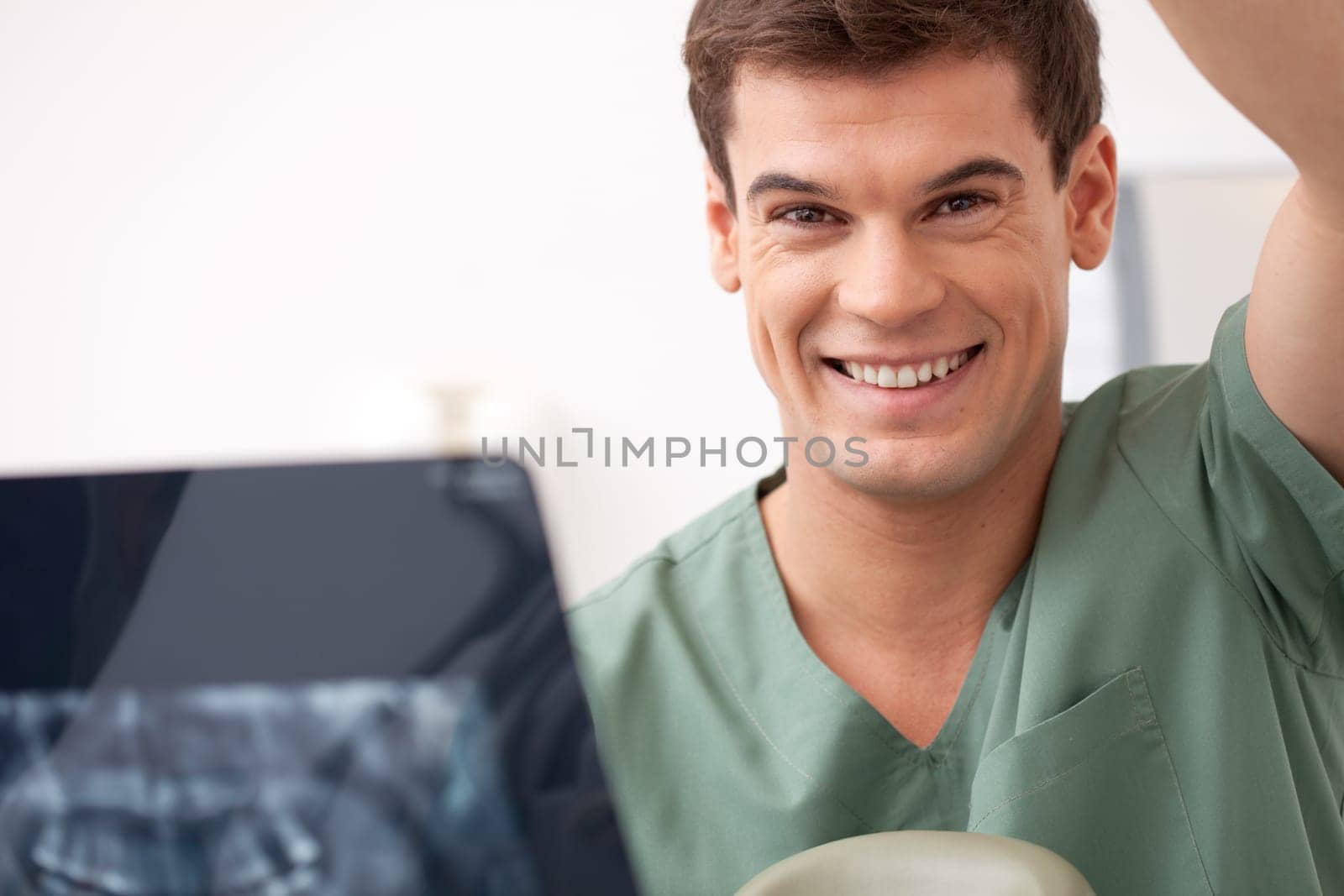 Dentist with xray in hand, smiling at the camera