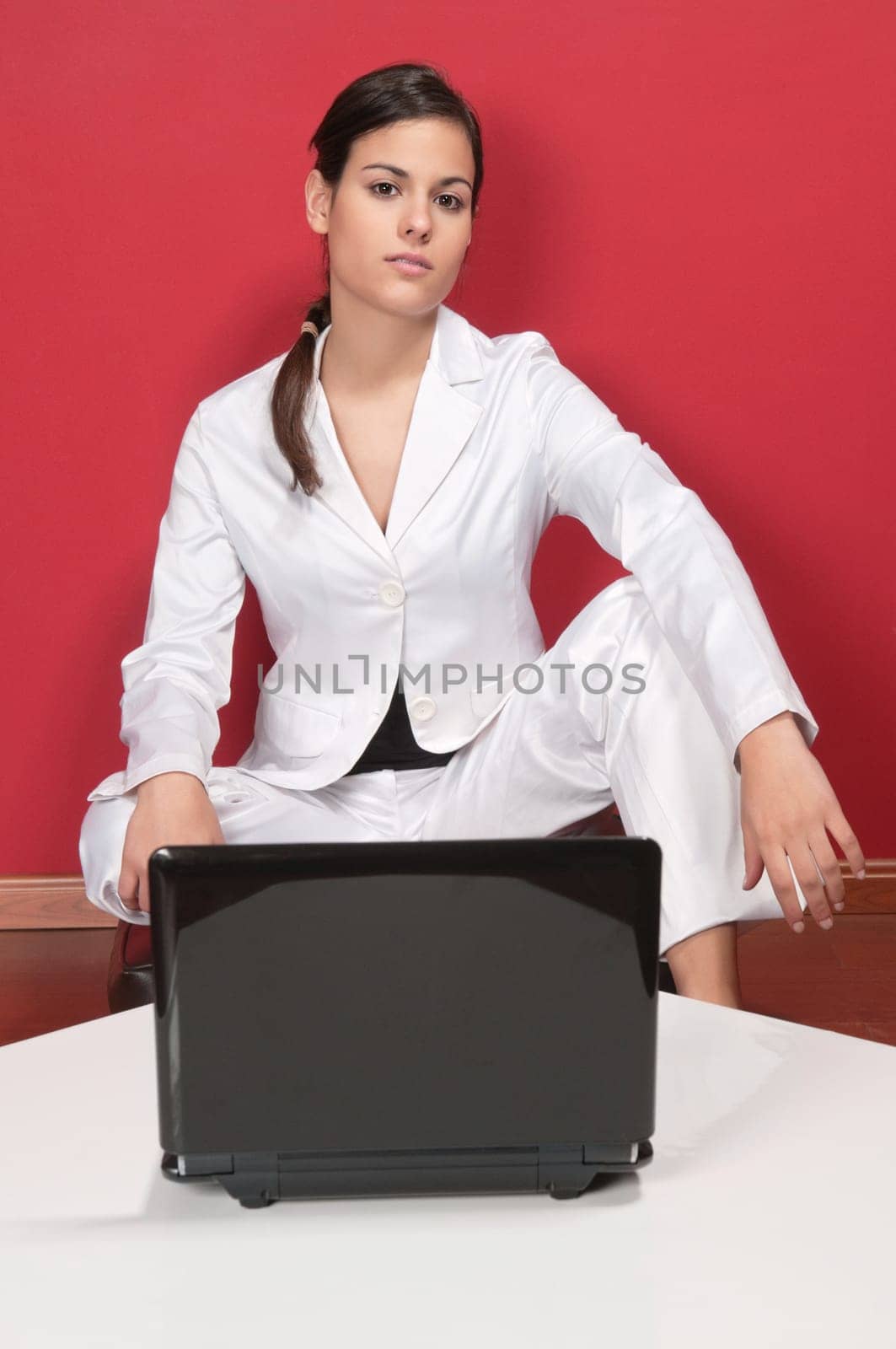 Portrait of smart businesswoman posing in front of laptop on table