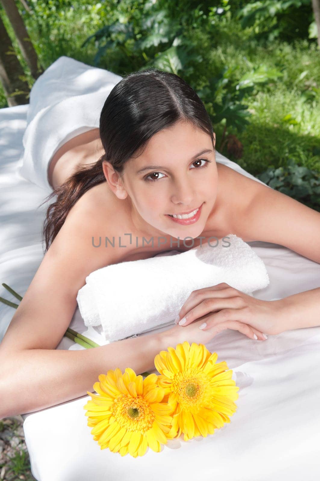 Portrait of fresh and beautiful young woman with flowers around