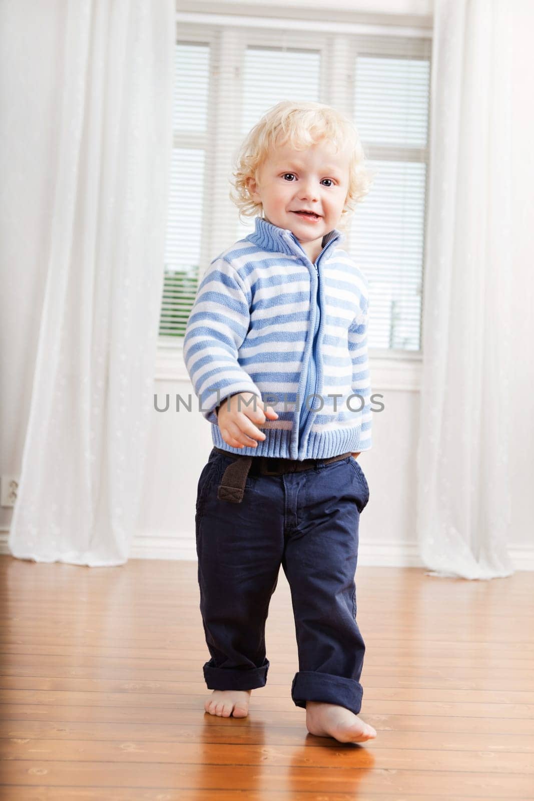 Full length of cute little boy walking on floor at home