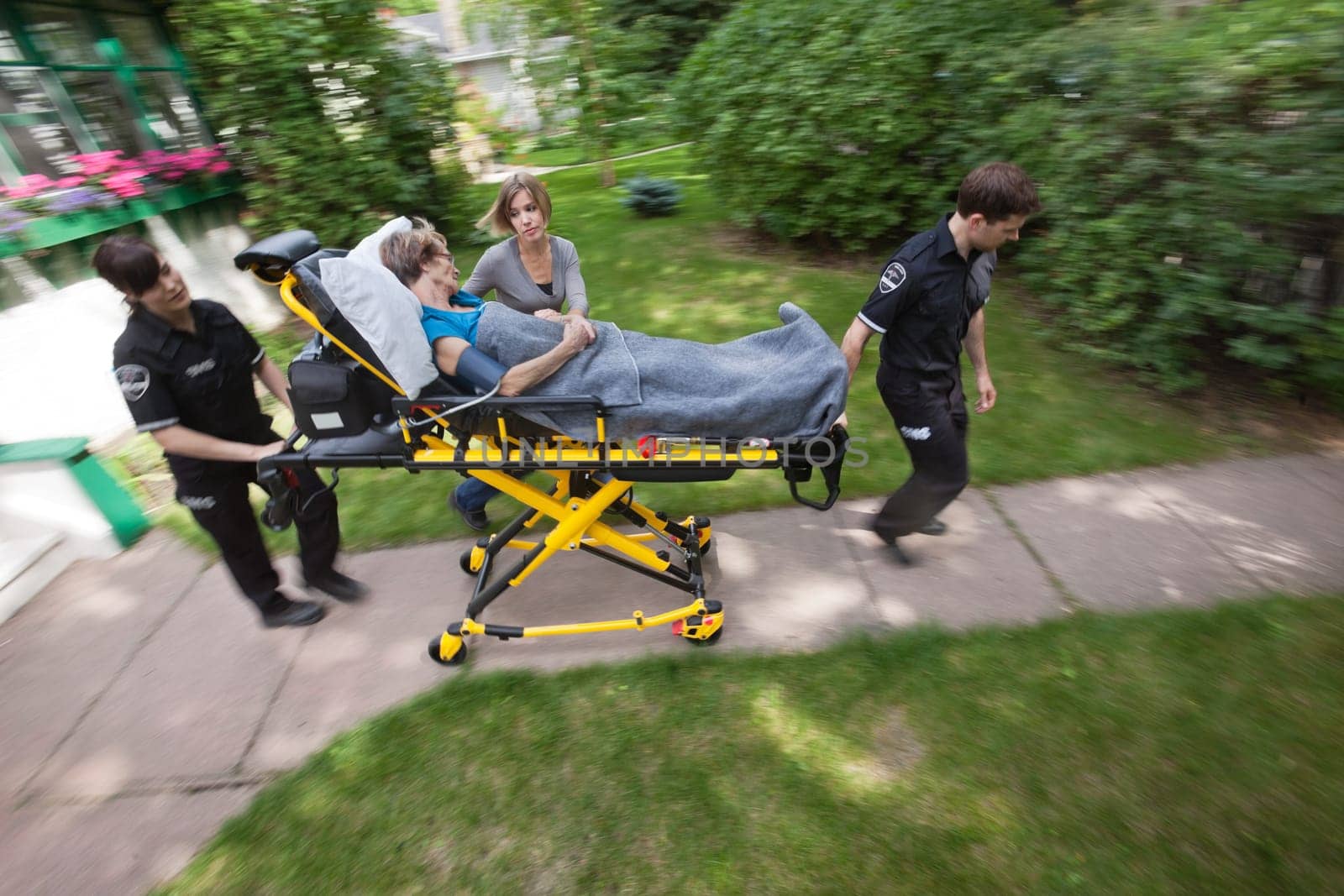 Above view of senior woman being rush to hospital by ambulance emergency medical workers