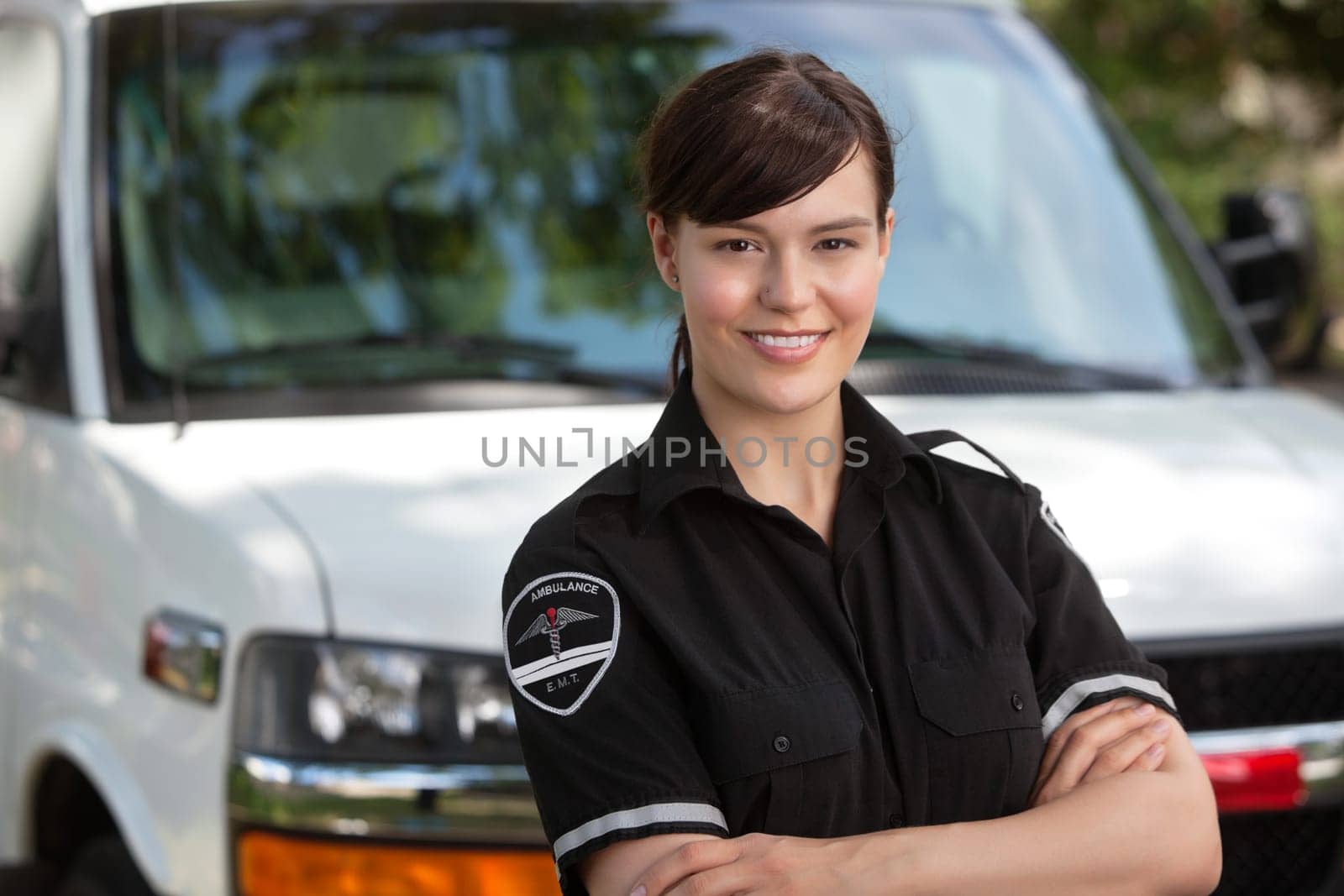 Portrait of a happy confident woman paramedic standing in front of ambulance