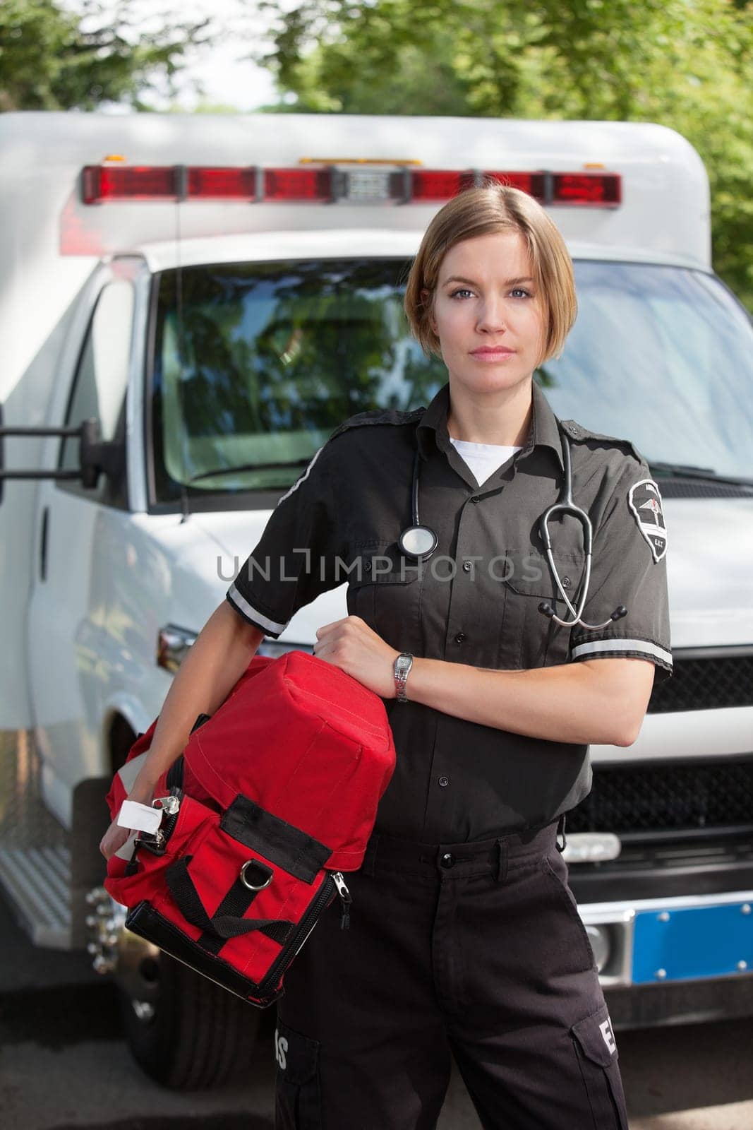 Portrait of an EMS professional carrying a protable oxygen unit